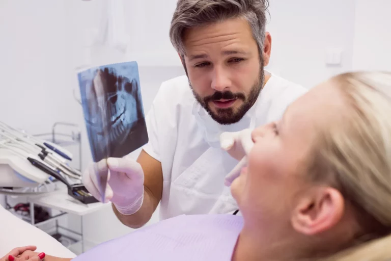 Dentiste qui explique une radiographie dentaire à sa patiente