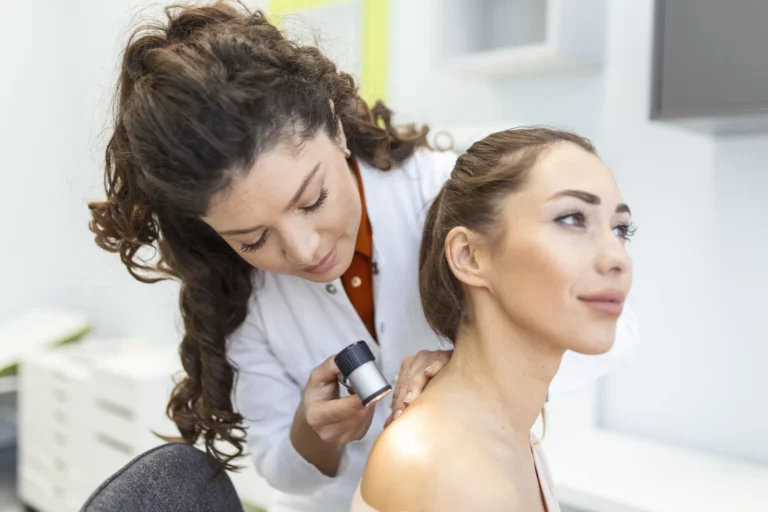 Dermatologue qui examine un grain de beauté au dermatoscope