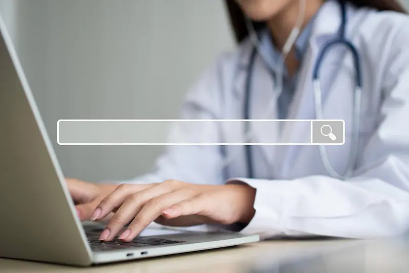 Médecin qui effectue une recherche sur son ordinateur portable