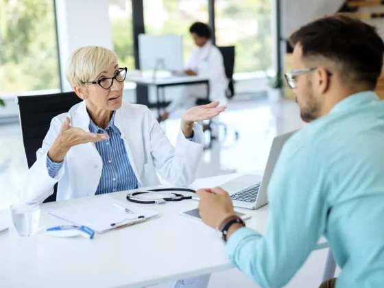 Médecin en consultation expliquant à un patient dans un cabinet lumineux